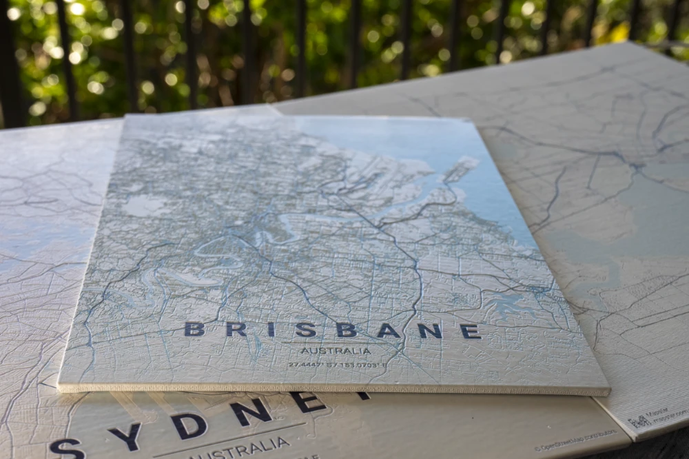 Adelaide wood-board map stacked on a Sydney print